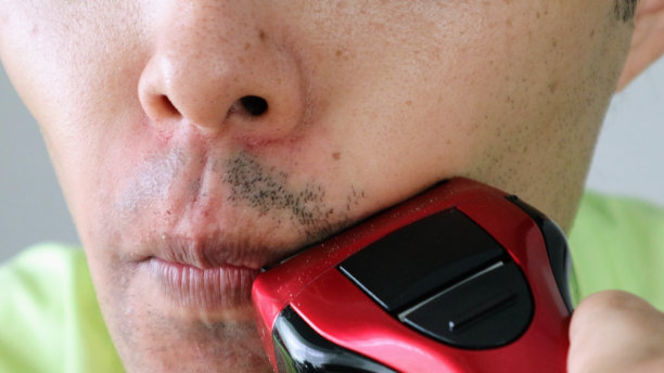 日本男子用电动剃须刀刮胡子图片下载