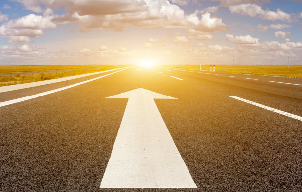 中国西部草原上柏油路上的白色箭头图片下载