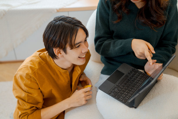 情侣们一边在家放松，一边在平板电脑上网购。图片下载