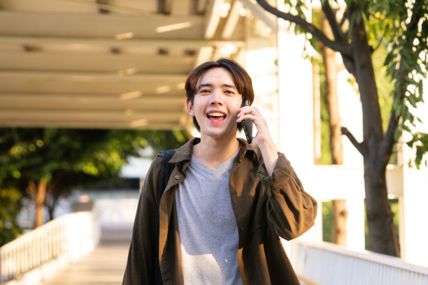 年轻的自由职业者使用智能手机进行业务联系。图片下载