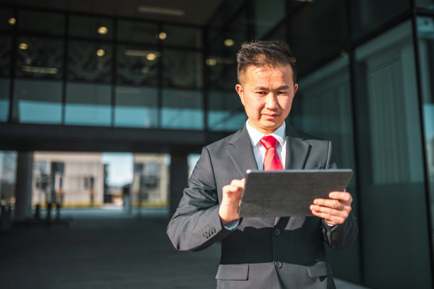 中国商人在商业区使用数码平板电脑图片下载