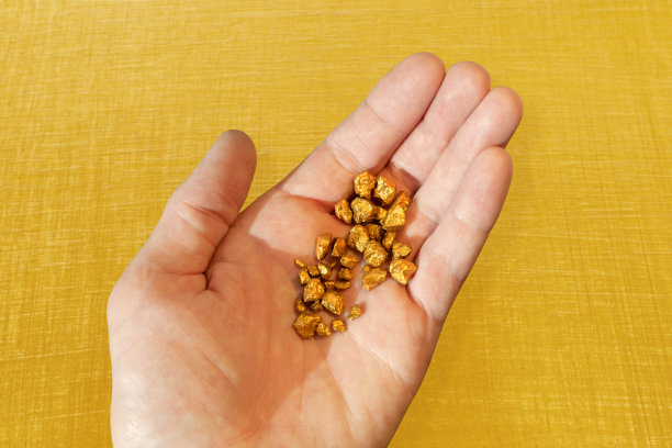 一个男人手里拿着金块，背景是明黄色的。图片下载