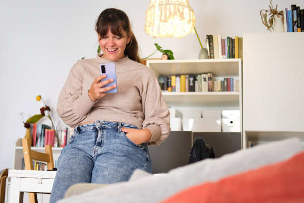 一个快乐美丽的白人女性在家里学习休息时用智能手机的一般照片图片下载