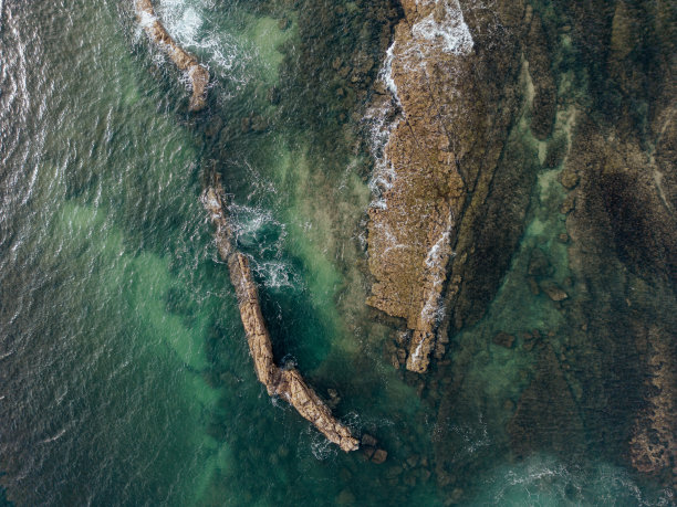 从空中俯瞰大海，沿着葡萄牙海岸的岩石形成纹理和形状图片下载