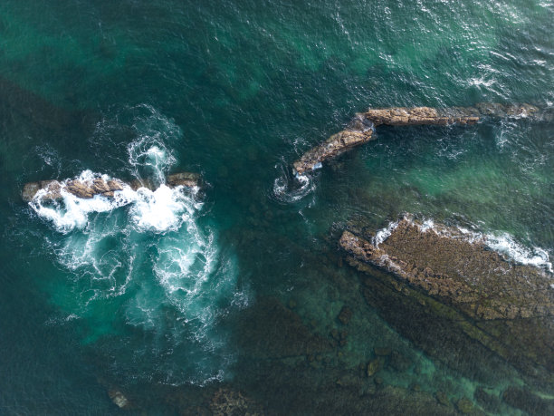从空中俯瞰大海，沿着葡萄牙海岸的岩石形成纹理和形状图片下载