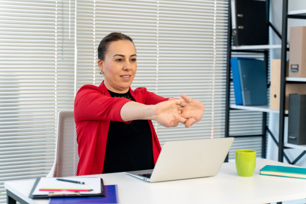 在办公室工作时做伸展运动的女人图片下载