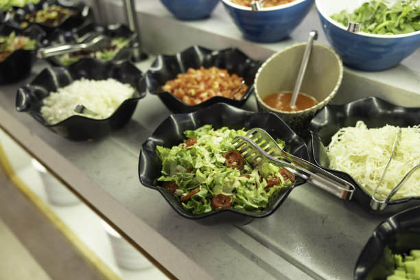 在酒店餐厅的自助餐桌上，用碗盛着新鲜蔬菜的沙拉图片下载