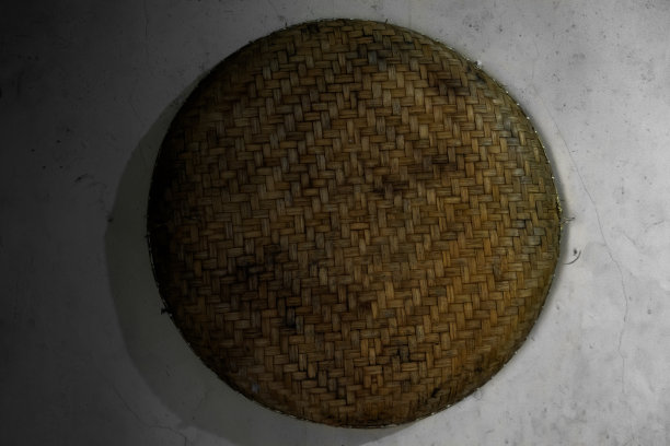 一种用编织的竹子制成的nyiru, tampah或筛分工具，挂在厨房的墙上。图片下载