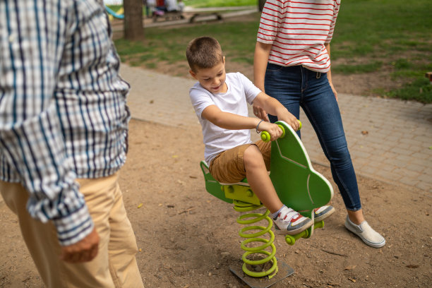 男孩和家人在公园操场上图片下载