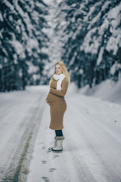 一个孕妇在雪林里摸自己的肚子图片下载