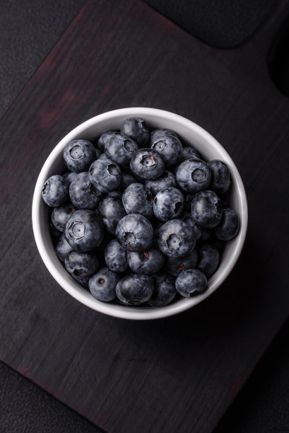 美味的新鲜甜蓝莓在一个陶瓷碗。素食图片下载