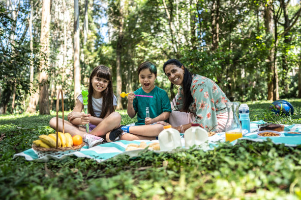 一家人在公园野餐时玩泡泡棒的照片图片下载