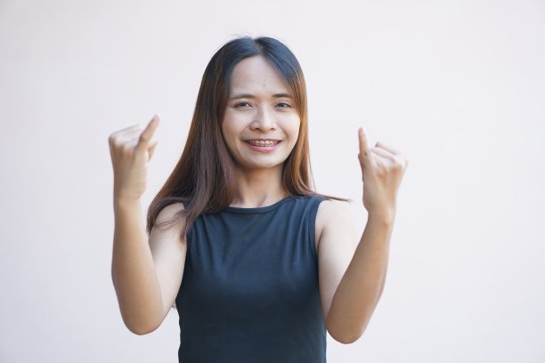 一个女人举起小指请求和解。图片下载