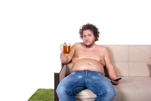 滑稽的胖子在家看电视。图片下载