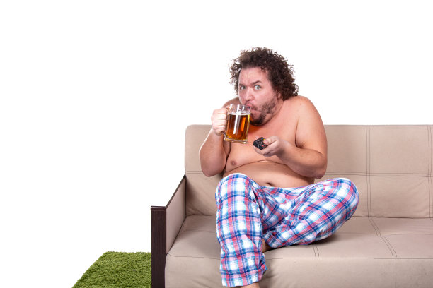 滑稽的胖子在家看电视。图片下载