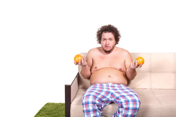 滑稽的胖子在家看电视。图片下载