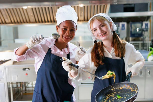 集体肖像年轻女子烹饪学生。烹饪课。烹饪教室。一群快乐的多民族女学生正在烹饪学校学习烹饪课程。图片下载