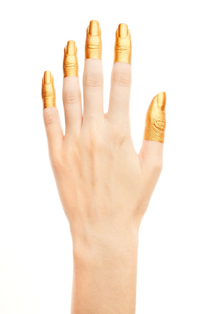双手涂上金色的颜料。金手指。女性的手被孤立在白色背景上。白人女性放松的手显示符号和手势。图片下载