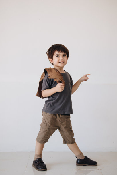 一个男孩的肖像，穿着灰色衬衫，肩上披着斗篷，面带微笑。图片下载