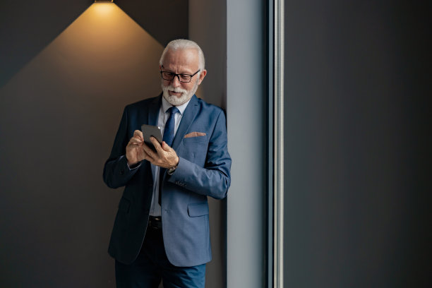 高级商人在现代办公室使用手机图片下载