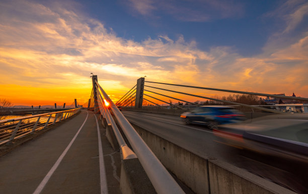 长时间曝光汽车在日落时在桥上移动图片下载