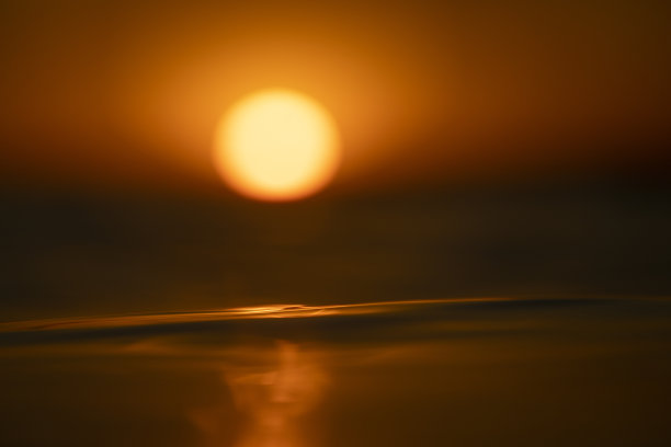 太阳在海面上落下的浅景深图片下载