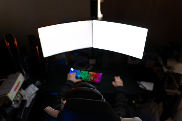 亚洲男性戴着耳机在网上玩电脑视频游戏。图片下载