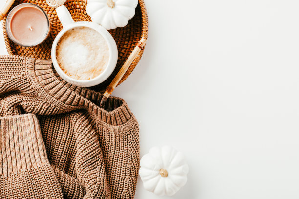 针织毛衣与咖啡杯，装饰南瓜，藤盘在白色背景。秋天，秋天，温馨家居概念图片下载