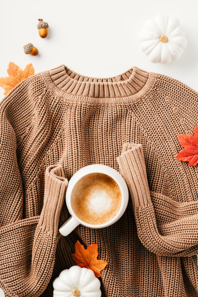针织套头衫，枫叶，南瓜，白色背景的咖啡杯。舒适的秋平构图。图片下载