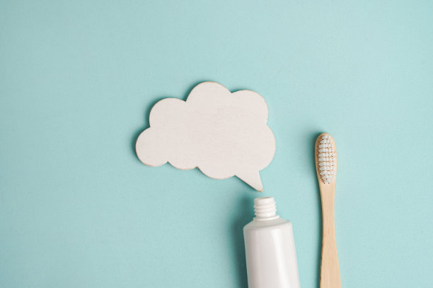 空白的白色牙膏管与白云和木刷在蓝色的背景，文字的地方图片下载