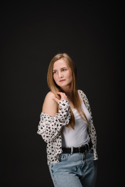 漂亮的女孩在看旁边。年轻严肃的女人被隔离在黑色的墙壁上。穿着休闲时尚服装的女士肖像在黑色背景下看起来很自信。照片。放文字的地方。图片下载