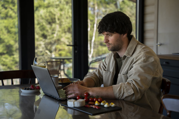 帅哥在家远程办公。快乐的自由职业者，在餐桌上吃早餐图片下载