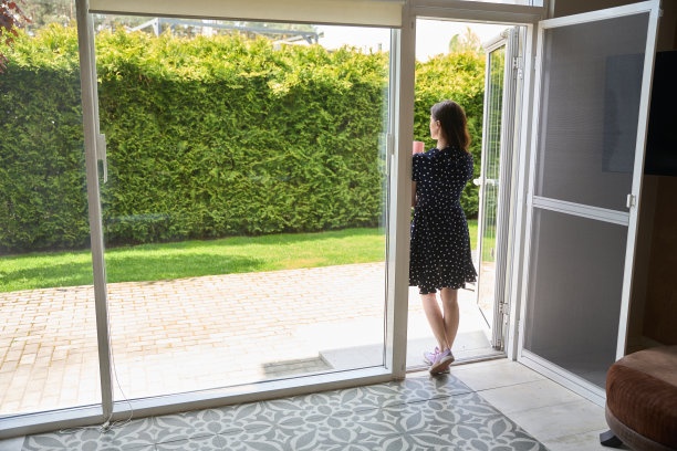 女人端着一杯茶站在门口图片下载
