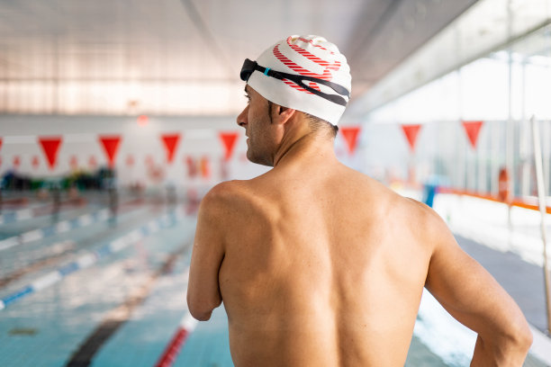 一名被截肢的成年游泳运动员在室内温水泳池里仰卧的照片。残障运动员的概念，截肢的游泳运动员。包容的运动。体育方面的进步。图片下载