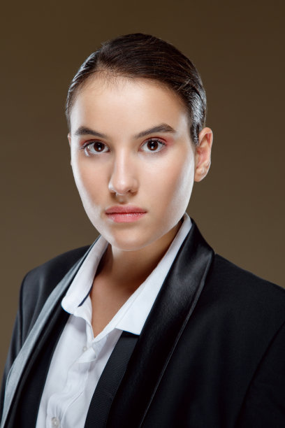 穿着白衬衫和黑夹克的黑发美女看着镜头的照片图片下载