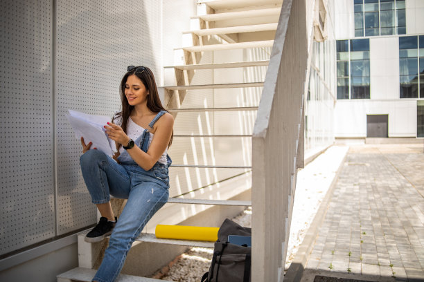 女学生在大学楼前的公园里图片下载