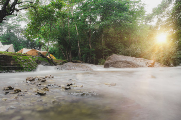 露营地户外帐篷露营野餐团瀑布区，装备自然露营区景观背景，以绿树成荫、绿草如茵，夏日出游放松和假日探险旅行的理念图片下载