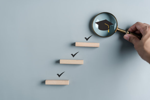 通往成功目标的教育步骤。为毕业采取战略性步骤。事业路径和第一为事业，毕业成就目标的理念。木块上的毕业帽。图片下载