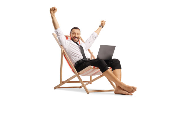 一个带着笔记本电脑度假的商人坐在那里，做着快乐的手势图片下载