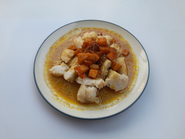 一道菜蔬菜烤饼(烤饼lontong sayur)与椰奶酱在一个盘子上的白色背景的顶部视图图片下载