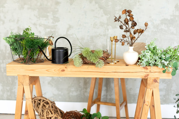 室内工作场所花店。木桌上有绿色的植物，干花和草本植物，背景是灰色的墙。夏天质朴风格的客厅。鲜花店。婚礼装饰图片下载