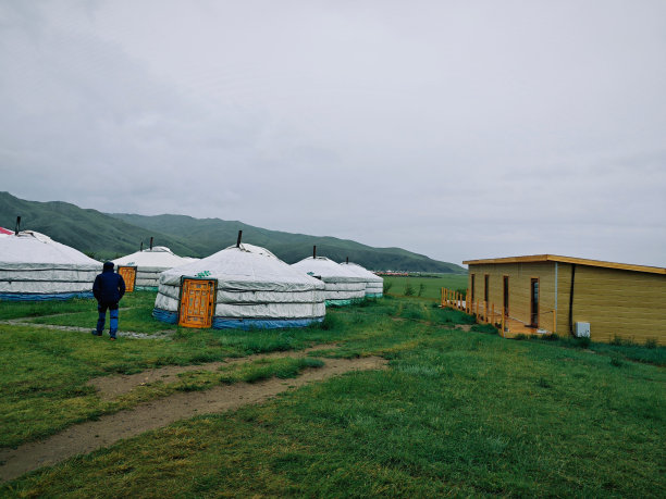 一个人看着有许多蒙古包帐篷的田野图片下载