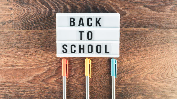回到学校的概念。木制背景的学习用品。回到学校的白色白板上的字母。文本的复制空间。包括选择性焦点图片下载