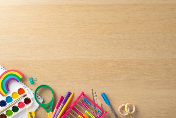 早教主题。各种充满活力的用品的俯视图:记号笔，画板，活页夹，胶带，放大镜，计数框，有文字或促销内容空间的木桌图片下载