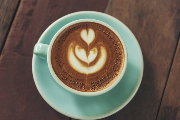 木桌上的拉花咖啡杯和牛奶。浓缩咖啡shot制作拉花热咖啡杯。意大利咖啡馆里的牛奶卡布奇诺。咖啡色热咖啡因饮料在自助餐厅，有复印空间图片下载