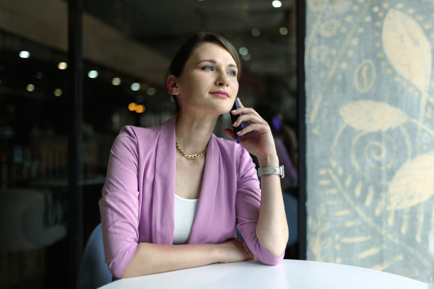 年轻的白人女子在空闲时间独自坐在咖啡馆里用智能手机打电话图片下载