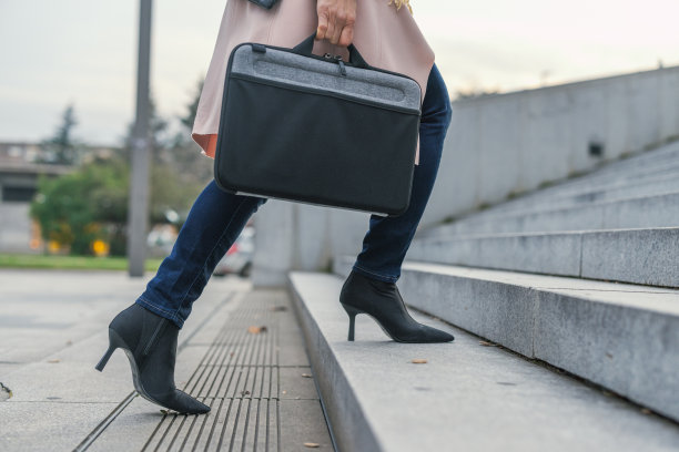 女商人拿着公文包爬上楼梯图片下载