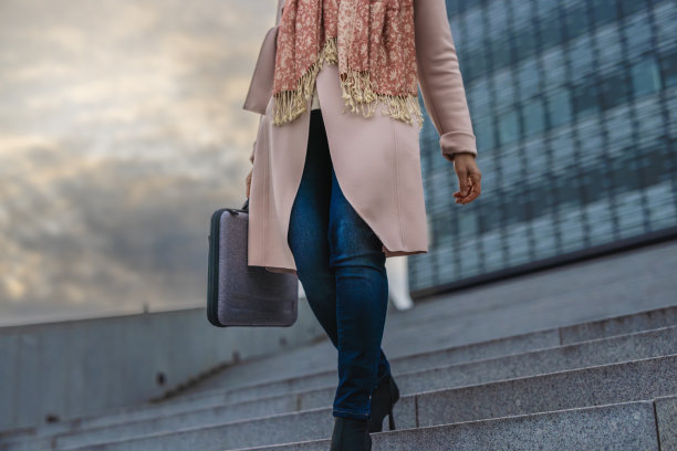 女商人提着公文包走下楼梯图片下载