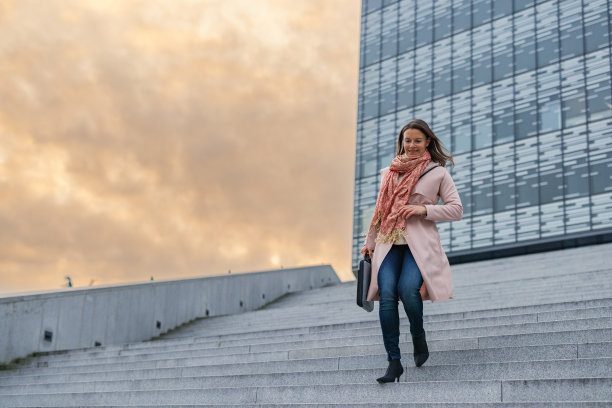 女商人提着公文包走下楼梯图片下载