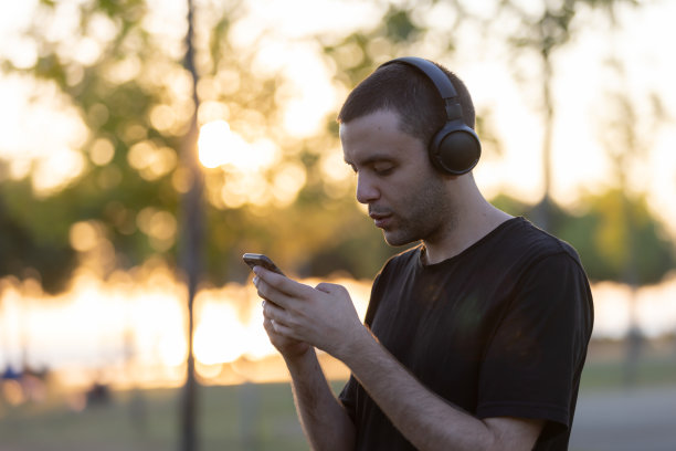 一个帅哥边听音乐边在手机上打字。图片下载